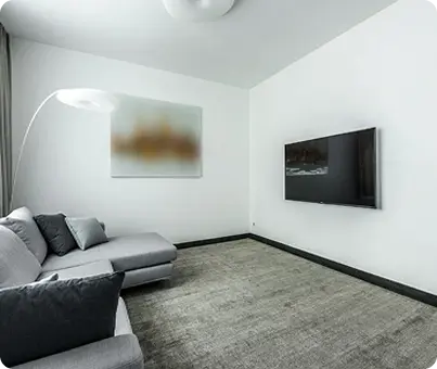 Minimalist-living-room-with-oak-hardwood-floors-gray-sectional-and-wall-mounted-TV
