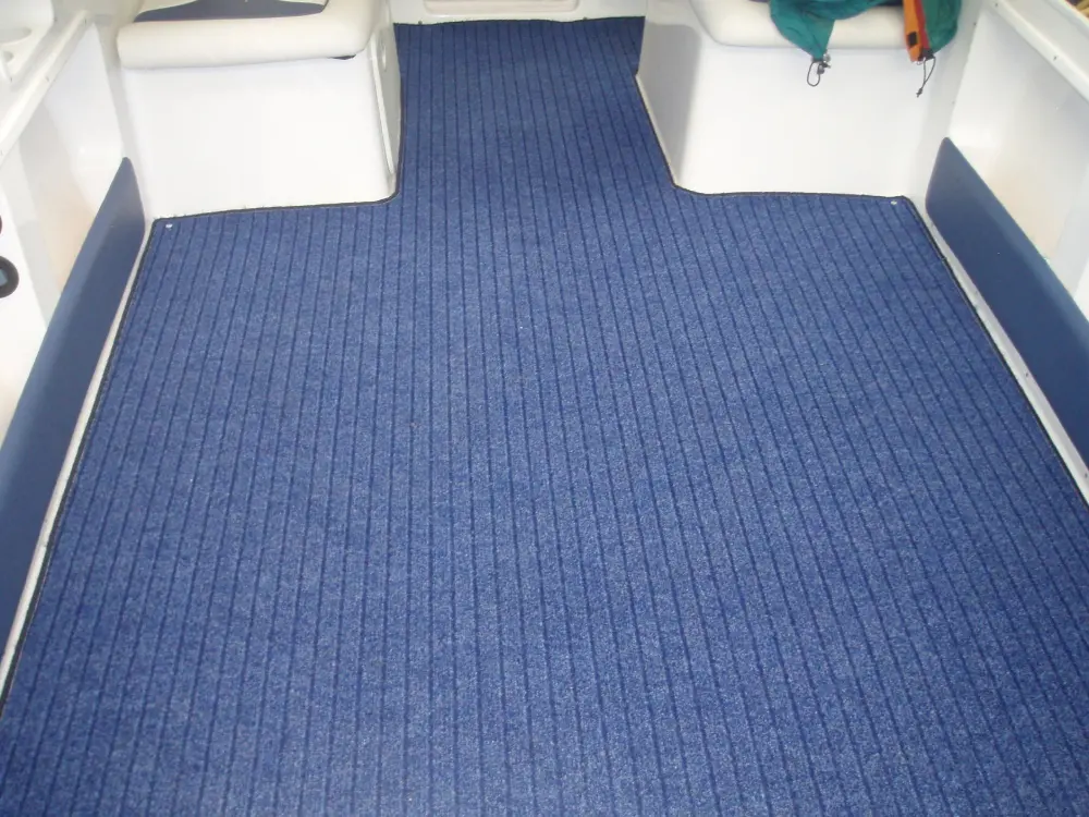 Interior deck of a boat fitted with custom blue ribbed marine carpet flooring