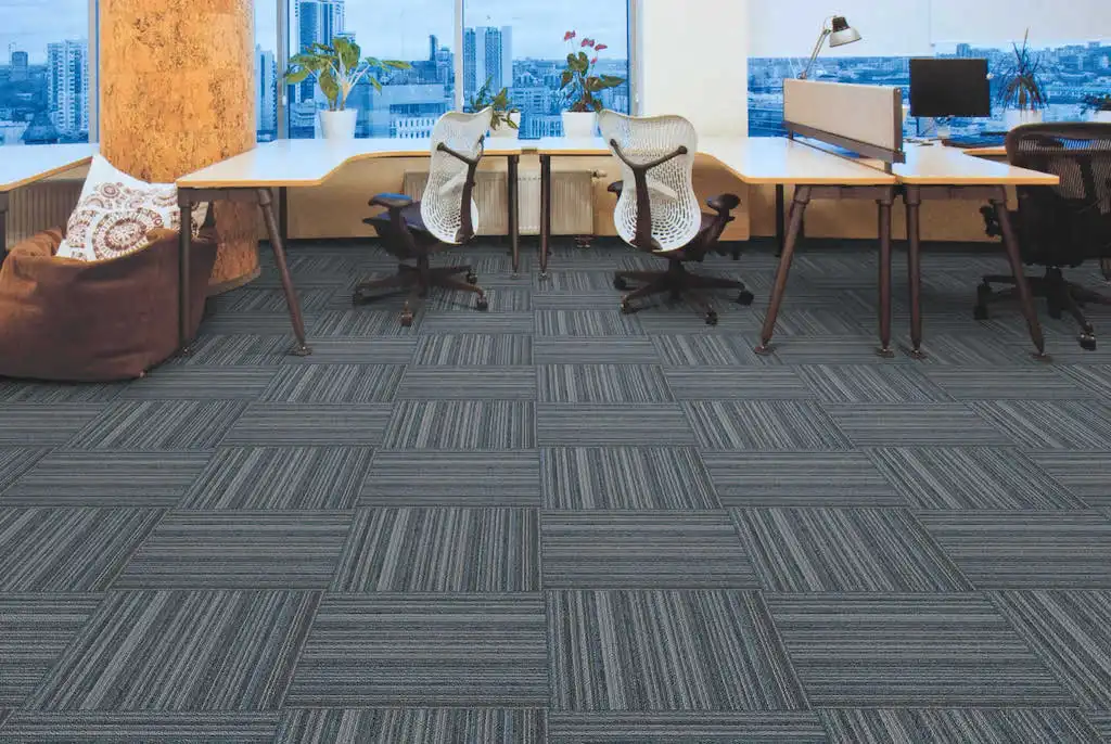 Modern open-plan office space featuring grey striped modular carpet tiles